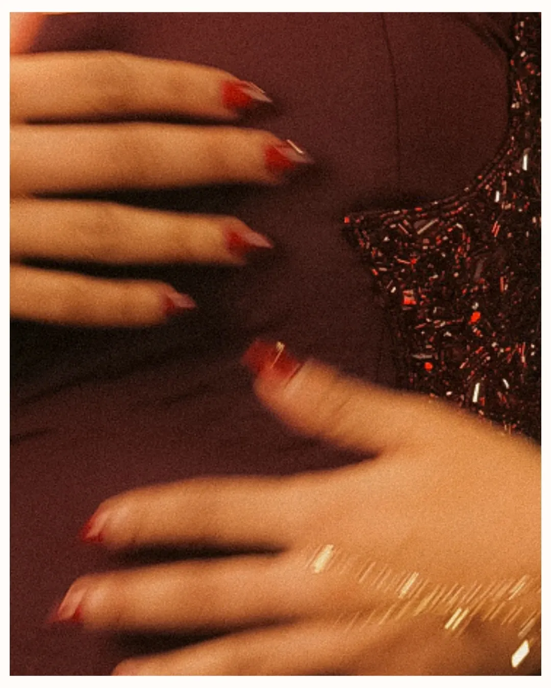 Hands with red nails over the corset’s embroidered edge
