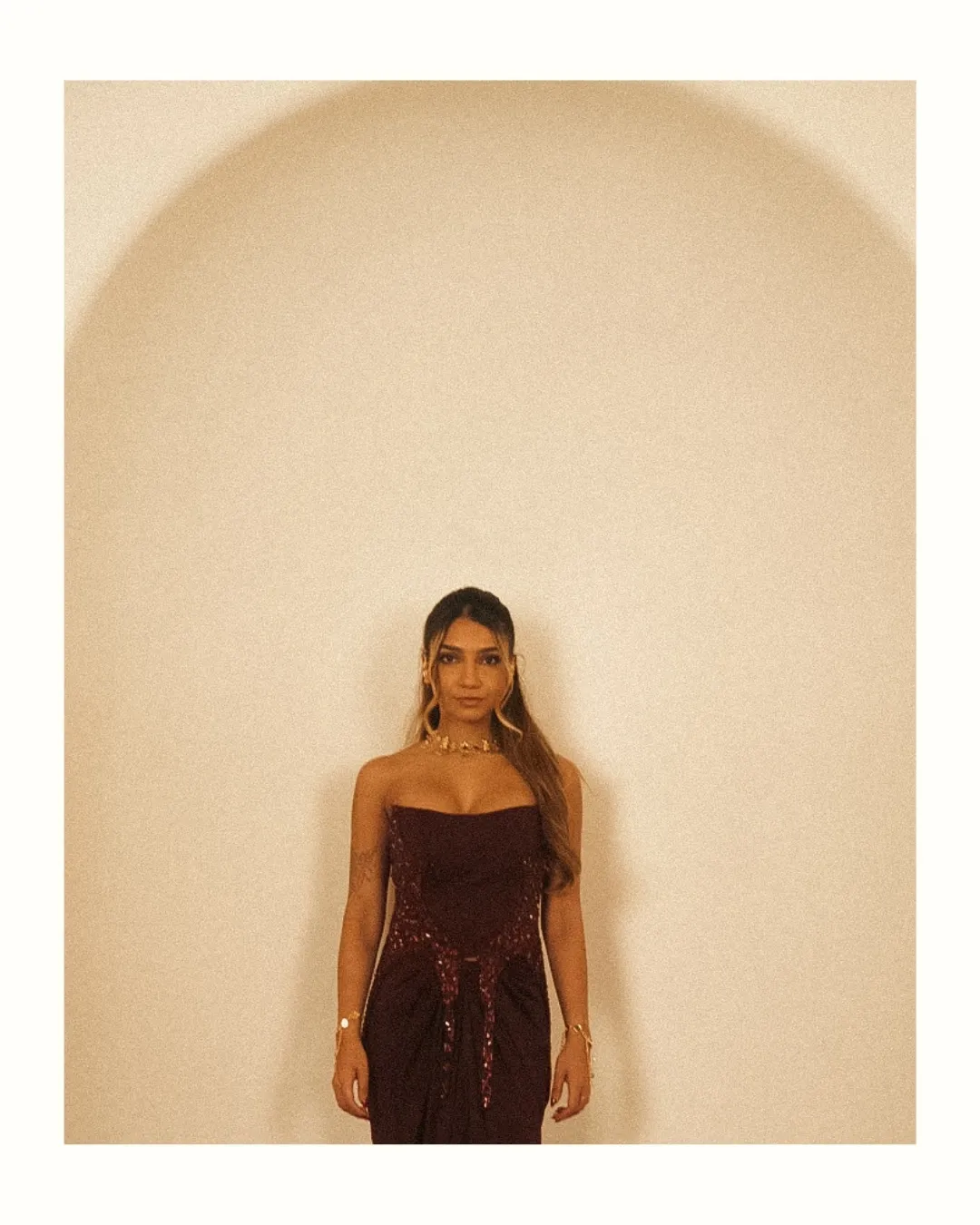 The full look, standing in a cream arch